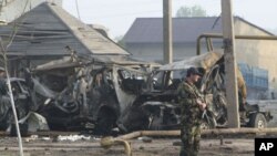 A police officer guards the site of a powerful explosion on the outskirts of Makhachkala, Dagestan, May 4, 2012. 
