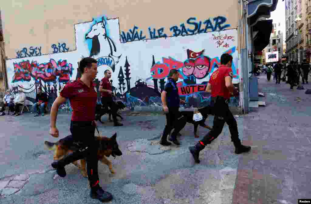 Police officers with dogs chase LGBT rights activists as they try to gather for a pride parade, which was banned by the governorship, in central Istanbul, Turkey, June 25, 2017.