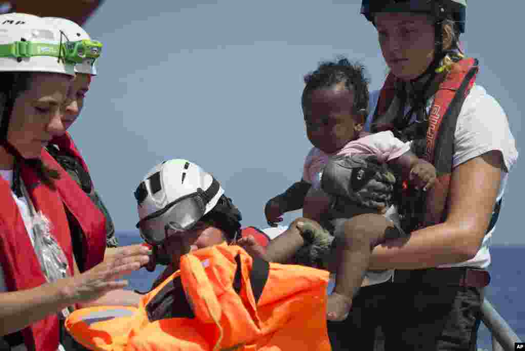 Rescuers put a life jacked on a child during a search and rescue operation conducted by SOS Mediterranee and MSF (Doctors Without Borders) NGOs, in the Mediterranean Sea, north of Libyan coast.