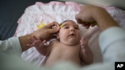 In this Dec. 22, 2015 photo, Luiza has her head measured by a neurologist at a hospital in Brazil's Pernambuco state. Her rare condition, known as microcephaly, could be caused by the Zika virus. Microcephaly often results in mental retardation. (AP Photo/Felipe Dana)