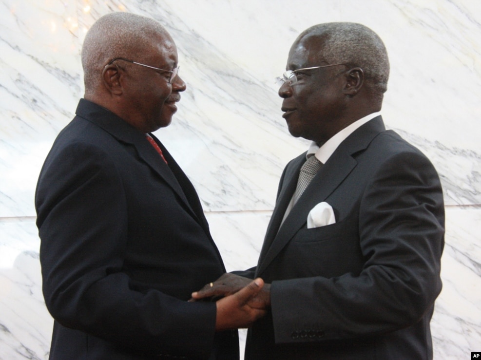 FILE - Mozambique President Arnando Guebuza, left, and former Renamo rebel leader Afonso Dhlakama, right, shake hands after signing a peace accord, Sept. 5, 2014.