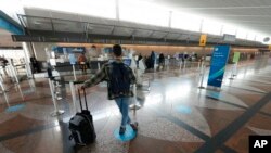 Lone traveler waits at the check-in counter for Alaska Airlines, Denver International Airport, Dec. 24, 2021.