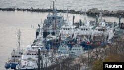 Navios ucranianos guardados pela guarda costeira russa no porto de Kerch, perto de ponte que liga a Rússia à península da Crimeia 