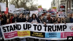 People hold a banner as they take part in a protest march in London, against U.S. President Donald Trump's ban on travelers and immigrants from seven predominantly Muslim countries entering the U.S., Feb. 4, 2017. 