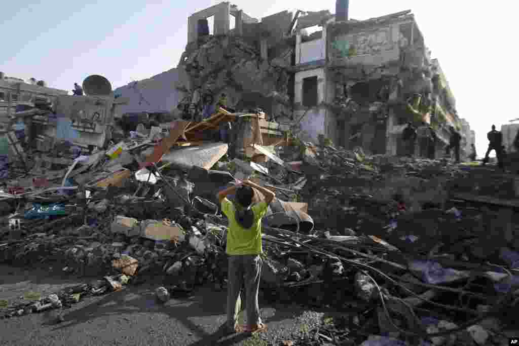 2012年11月20日，巴勒斯坦儿童站在废墟上。这所位于加沙市的房屋被以色列击中。 