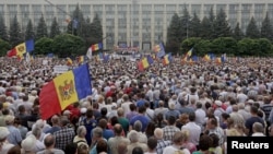 Protesters carry Moldova's national flags during an anti-government rally, organised by the civic platform "Dignity and Truth" (DA), in central Chisinau, Moldova, Sept. 6, 2015. 