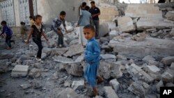 FILE - Children play amid the rubble of a house destroyed by a Saudi-led airstrike in Sana'a, Yemen, Sept. 8, 2015. 