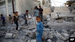 Trẻ em chơi đùa giữa những đống đổ nát của một ngôi nhà bị phá hủy vì 1 cuộc không kích do Ả Rập Xê-út lãnh đạo, ở Sana'a, Yemen, 8/9/2015.