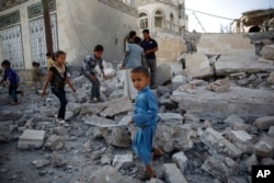 FILE - Children play amid the rubble of a house destroyed by a Saudi-led airstrike in Sana'a, Yemen, Sept. 8, 2015.