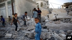 FILE - Children play amid the rubble of a house destroyed by a Saudi-led airstrike in Sana'a, Yemen, Sept. 8, 2015. 