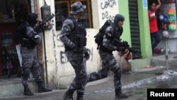 Policemen take position during an operation against drug gangs in the Alemao slums complex of Rio de Janeiro, Brazil Oct. 9, 2018.