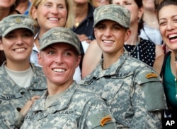 FILE - U.S. Army 1st Lt. Shaye Haver, center, and Capt. Kristen Griest, right, pose for photos with other female West Point alumni after an Army Ranger school graduation ceremony at Fort Benning, Ga., Aug. 21, 2015.