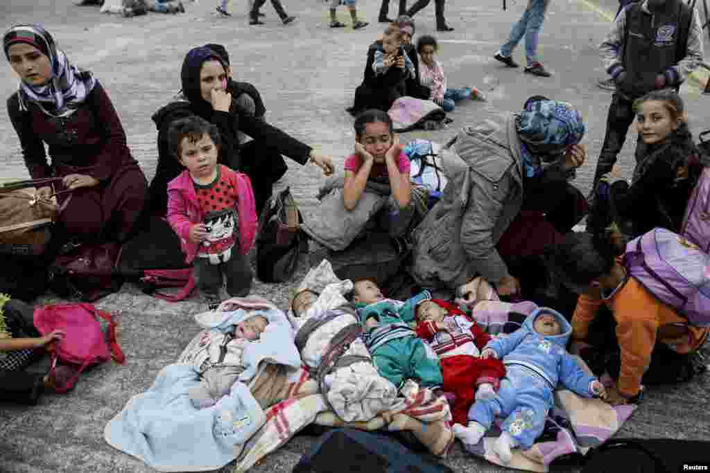 Five Syrian babies, three of them triplets (L - C), lie in blankets among their relatives as they arrive with other refugees and migrants aboard the passenger ferries Blue Star Patmos and Eleftherios Venizelos from the islands of Lesbos and Chios at the port of Piraeus, near Athens, Greece.