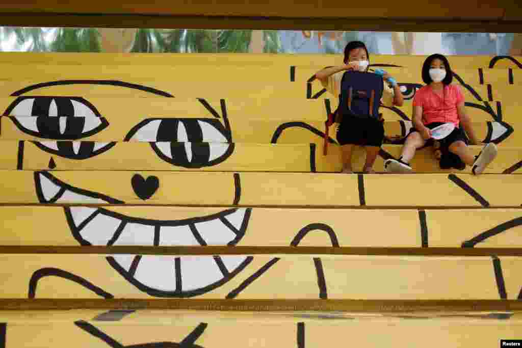 Students wearing masks rest amid the coronavirus disease (COVID-19) pandemic in Seoul, South Korea.