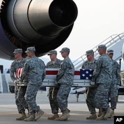 An Army carry team carries the transfer cases containing the remains of Army Spc. Scott D. Smith of Indianapolis, Indiana upon arrival at Dover Air Force Base, Delaware on June 21, 2011.