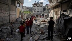 加沙城的居民在以色列周一早上空袭后的瓦砾堆里行走。（2021年5月17日）