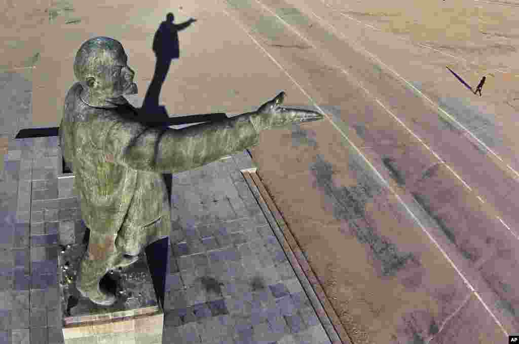 A woman walks past a statue of Soviet Union founder Vladimir Lenin at the Russian leased Baikonur cosmodrome in Kazakhstan.