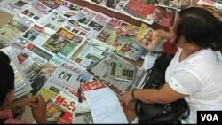 Burmese customers at a news stand. 