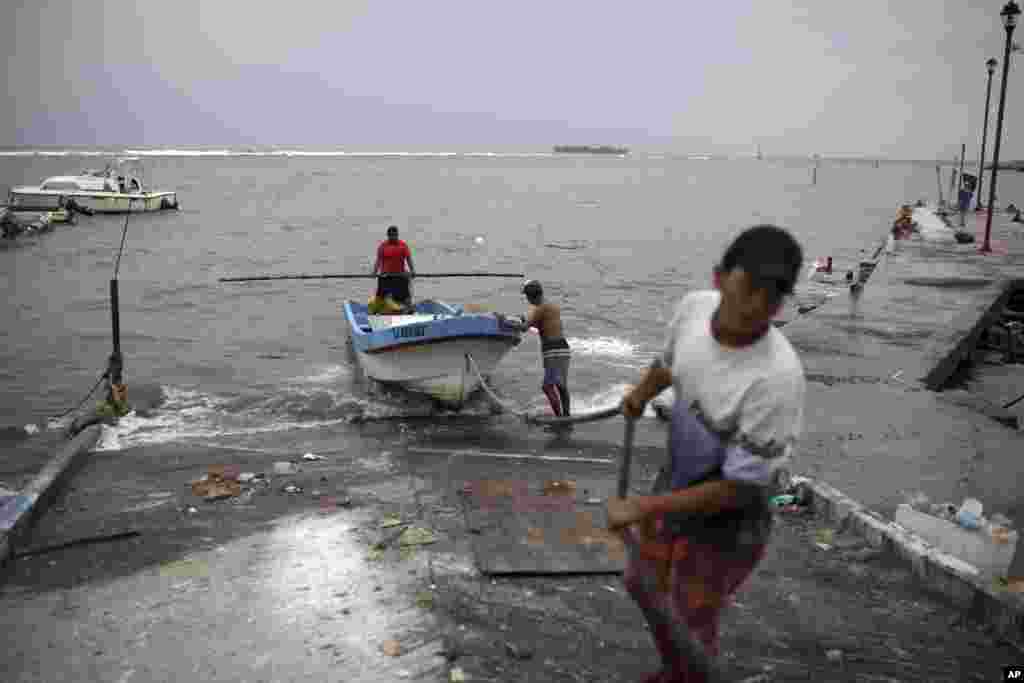 Pescadores arrastran un bote a tierra para protegerlo antes de la llegad del huracán Franklin a Veracruz, México. Agosto 9, 2017.