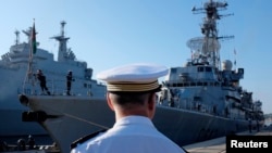 A French Navy Captain looks at the French Navy frigate Montcalm arriving at the naval base in Toulon, France, Aug. 1, 2014. French and British warships will sail the South China Sea in a display of naval strength.