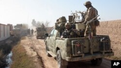 FILE - In this Dec. 22, 2015 photo, Afghan security forces patrol in Nad Ali district of Helmand province, Afghanistan. 