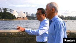 Australia's Prime Minister Malcolm Turnbull walks with Chinese Premier Li Keqiang along the Sydney Harbor in front of the Sydney Opera House in Australia, March 25, 2017. 