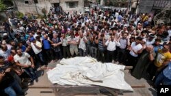 Warga Palestina melakukan shalat jenazah bagi sebuah keluarga yang tewas akibat serangan Israel di Jalur Gaza (22/7).