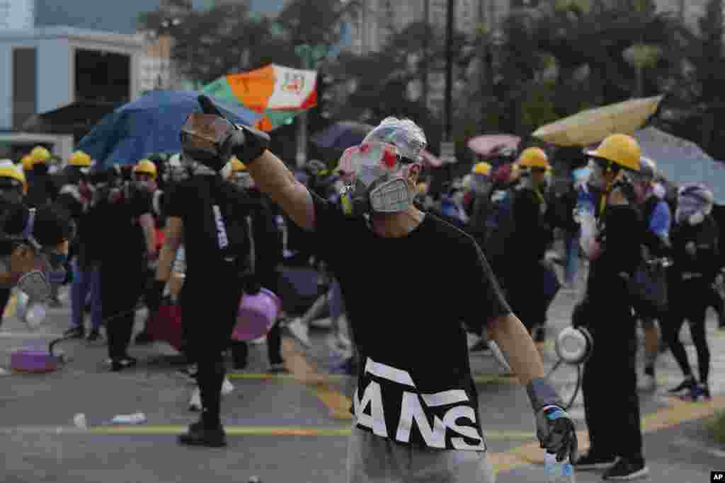 معترض آجر به دست در هنگ کنگ. همزمان با برخورد شدید پلیس با معترضان در هنگ کنگ، آنها هم با خشونت پاسخ دادند. مردم معترض به دخالت های چین هستند.&nbsp;
