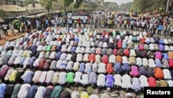 Muslims pray while Christians form a protective human chain around them during a protest on common problems faced in Nigeria, January 10, 2012.