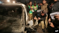 Policemen survey the site of a deadly suicide bomb attack in Lahore, 25 Jan 2011.