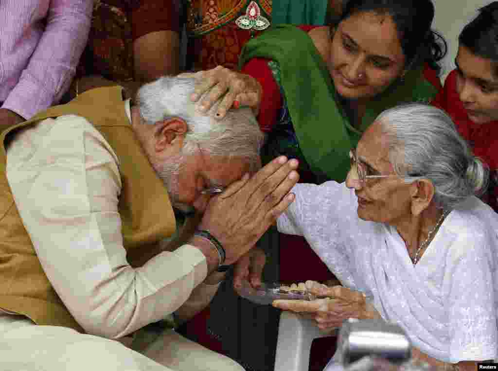 Hindu nationalist Narendra Modi, the preseumptive prime minister of India and leader of the opposition Bharatiya Janata Party (BJP), seeks blessings from his mother, Heeraben, at her residence in Gandhinagar, in the western state of Gujarat, May 16, 2014.