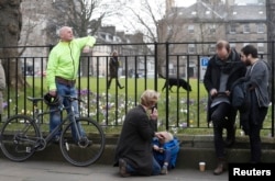 People listen and watch on their mobile devices as Scotland's First Minister Nicola Sturgeon demands a new independence referendum, outside Bute House, in Edinburgh, March 13, 2017.