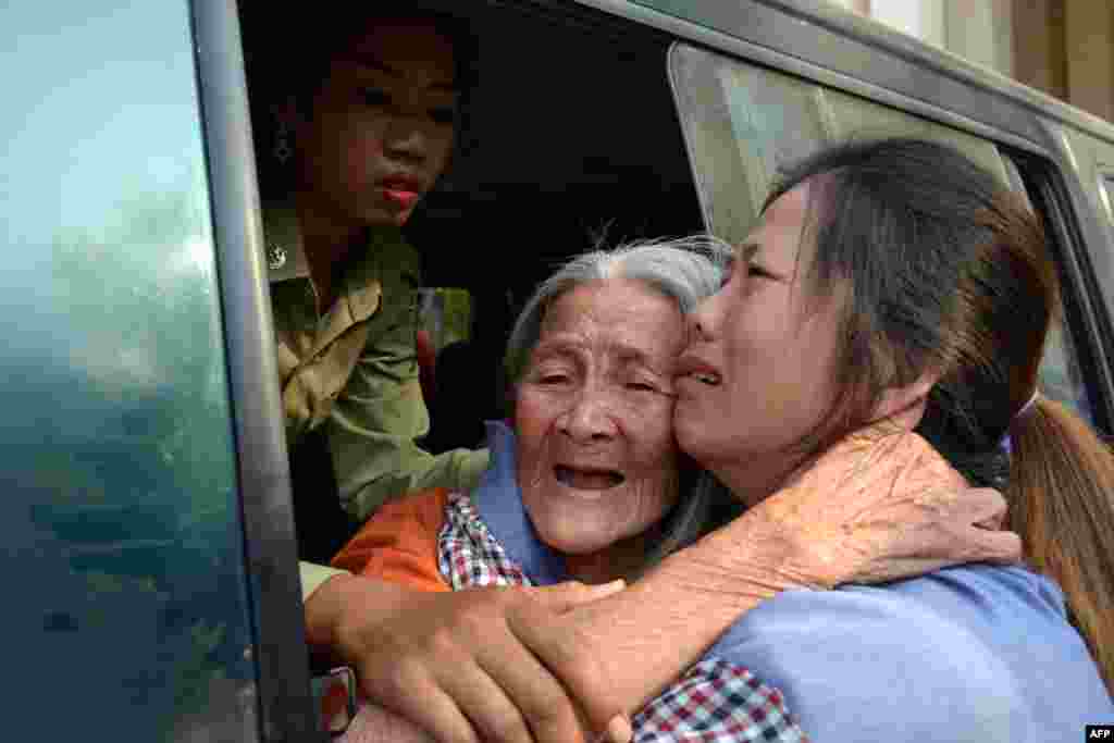 Cambodian land rights activist Nget Khun (C), known locally as &quot;Mommy&quot;, hugs her daughter (R) through a window of a prison car at the Appeal Court in Phnom Penh. A Cambodian court upheld convictions for 10 female land rights activists and a defrocked Buddhist monk and reduced the one-year sentence for most of them.