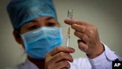In this file photo, a health worker prepares a dose of H1N1 vaccine at the start of a free vaccination program intended for all Beijing residents at a clinic in Beijing.