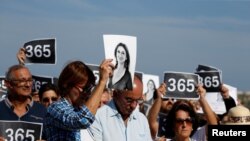 People attend three minutes of silence as they gather at the site where anti-corruption journalist Daphne Caruana Galizia was assassinated in a car bomb one year ago, in Bidnija, Malta October 16, 2018. 