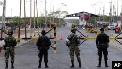 FILE - Colombian police officers and soldiers patrol the border between Colombia and Venezuela, in Paraguachon, Colombia, Sept. 9, 2015.