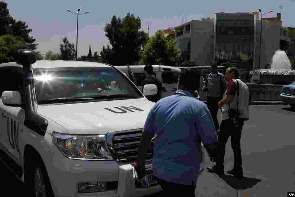 BMT avtomobili Damashqda xuruj sodir bo&#39;lgan Milliy xavfsizlik idorasi yonida turibdi, 18-iyul, 2012-yil.