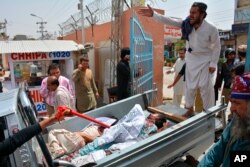 Volunteers rush injured persons to a hospital in Pakistan's southwestern city of Quetta, July 25, 2018, after a suicide bomber struck outside a crowded polling station.