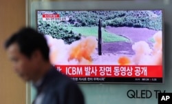 FILE - A man walks past a TV screen showing a local news program about North Korea's firing of an ICBM, at Seoul Train Station in Seoul, South Korea, July 5, 2017. The launch has prompted the U.S. to call for stronger sanctions against Pyongyang.