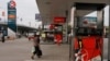 A woman walks through a closed Caltex gas station during a strike Monday, May 12, 2014, in Phnom Penh, Cambodia. Workers at gas stations in Cambodia owned by the U.S. oil company Caltex have gone on strike to demand higher wages and better working conditions. A strike leader, Sar Mora, said at least 250 Cambodian employees of Caltex halted work Monday, forcing at least 17 of the company's 26 stations to suspend operating. (AP Photo/Heng Sinith)