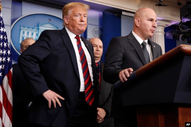 President Donald Trump, left, listens as Brandon Judd, president of the National Border Patrol Council, talks about border security, Jan. 3, 2019, after making a surprise visit to the press briefing room of the White House.