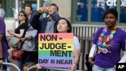 FILE- LGBT activists hold up a sign at the 44th annual San Francisco Gay Pride parade Sunday, June 29, 2014, in San Francisco, California.