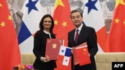 FILE - Panama's Vice President and Foreign Minister Isabel de Saint Malo (L) and Chinese Foreign Minister Wang Yi pose with their documents after signing a joint communiqué on establishing diplomatic relations, in Beijing, June 13, 2017. 