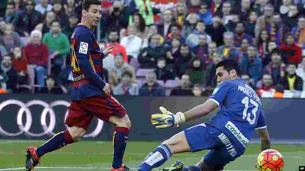 Un but de "Léo", Lionel Messi, à gauche, face au gardien Andres Fernandez de Grenade au cours d’un match de football de la Liga espagnole entre Barcelone et Grenade, au stade Camp Nou à Barcelone, Espagne, 9 janvier 2016.