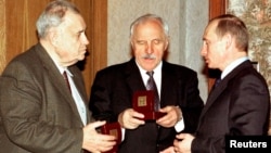 FILE - Russian President Vladimir Putin (R) gives birthday presents to Russian famous actor Mikhail Ulyanov (center) and famous movie director and producer Eldar Ryazanov (left) in his residence in Novo-Ogaryovo outside Moscow, November 20, 2002. 
