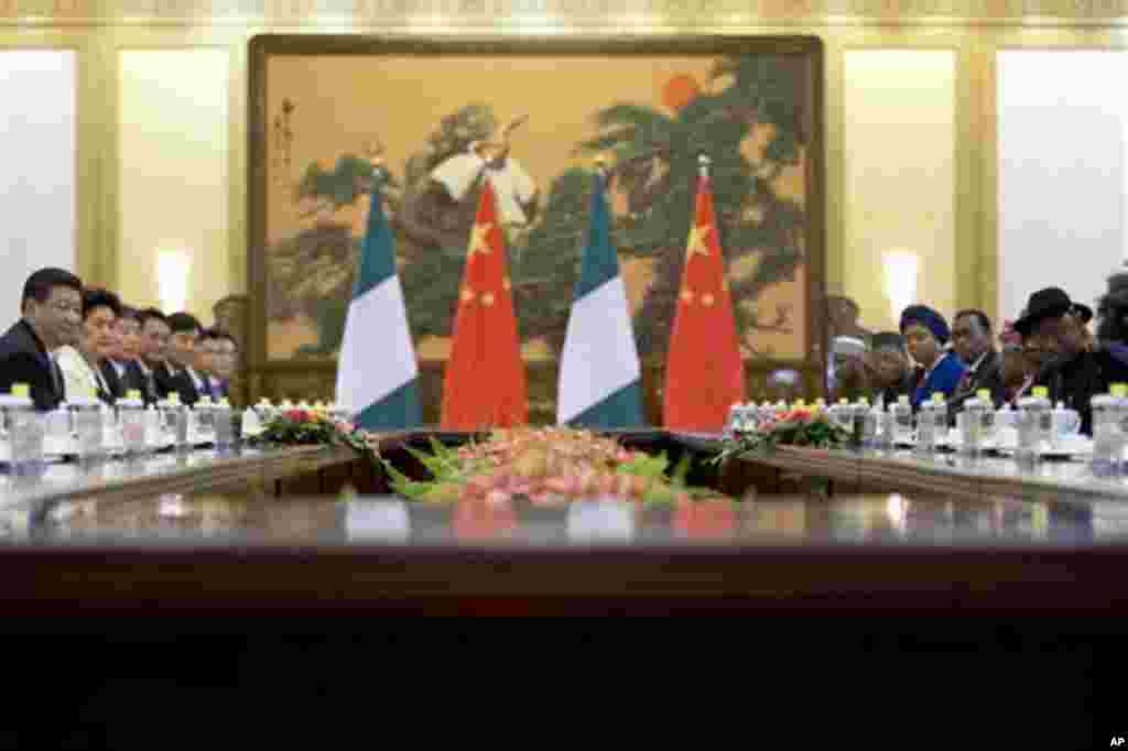 Nigerian President Jonathan gestures to introduce ministers of his cabinet while Chinese President Xi Jinping watches during their meeting at the Great Hall of the People in Beijing.