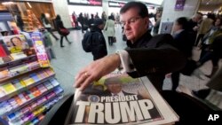 미국 대선 다음날인 9일 아침 출근길 뉴욕 시민이 '트럼프 대통령'이라고 1면에 적힌 뉴욕포스트 신문을 집어들고 있다. 
