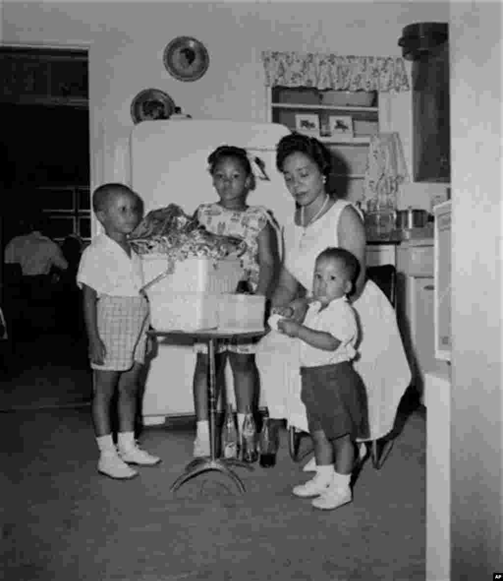 Mrs. Martin Luther King, wife of the jailed integration leader, Rev. Martin Luther King, Jr., gets assistance from their three children as they pack this picnic basket with extra provisions at their Albany, Ga. temporary home, August 5, 1962. From left ar