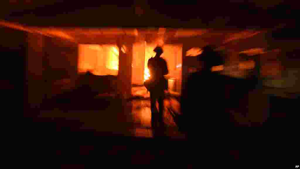 Un pompier inspecte une maison en feu le 15 août 2016, à Lower Lake.