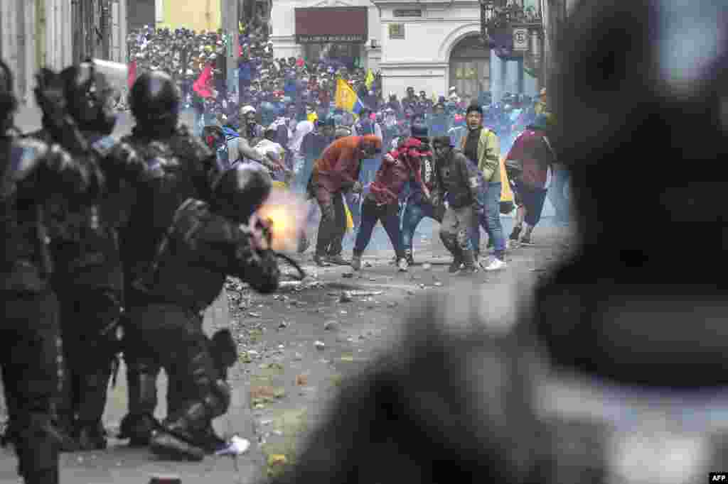 Demonstrators clash with riot police as thousands march against Ecuadorean President Lenin Moreno&#39;s decision to slash fuel subsidies, in Quito.
